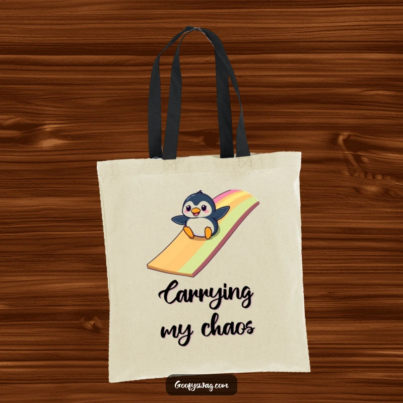 Funny clumsy penguin sliding down a colorful rainbow ramp, a durable and humorous tote bag for everyday use.
