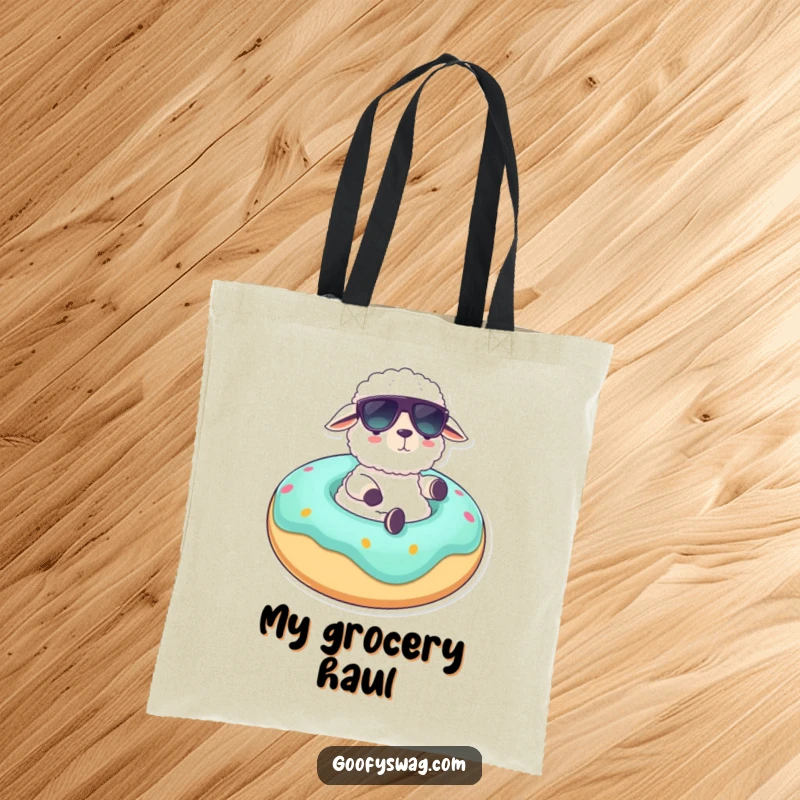 Funny tote bag depicting a fluffy sheep wearing sunglasses lounging on a giant donut float, ideal for carrying beach gear with humorous leisure.